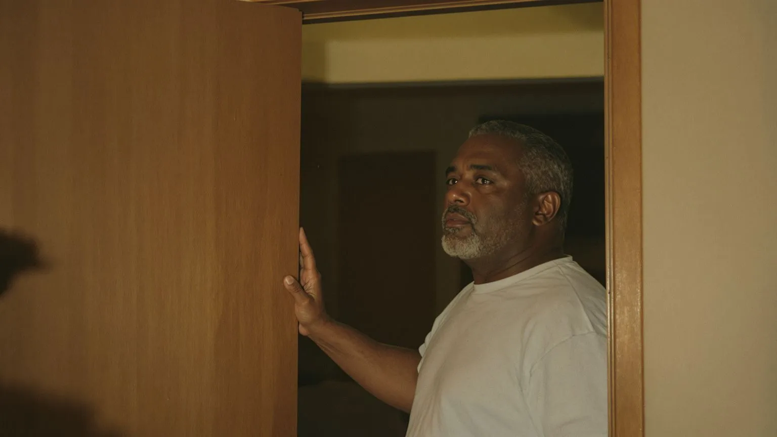 Man frozen mid-step in doorway showing subtle freeze response pattern in the body Man frozen mid-step in doorway showing subtle freeze response pattern in the body