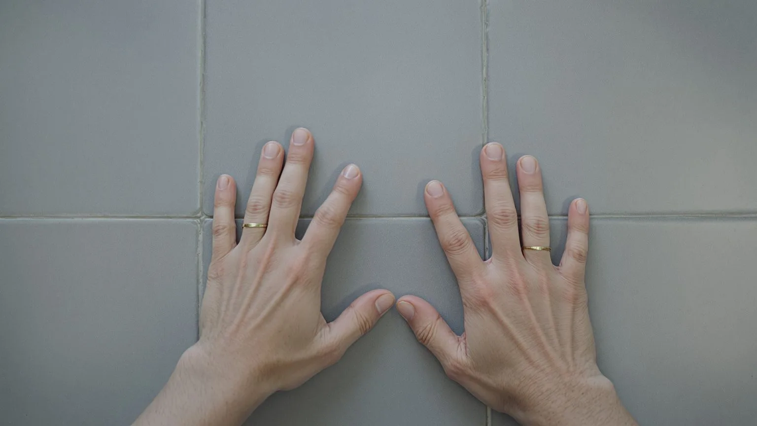 Hands pressing firmly into ceramic floor tiles as a grounding technique during a somatic eating urge Hands pressing firmly into ceramic floor tiles as a grounding technique during a somatic eating urge