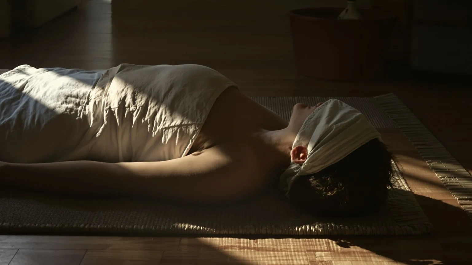 Person lying on floor mat with palms down and eyes covered during 12-minute mental exhaustion reset