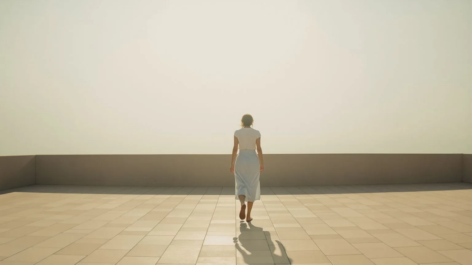 Woman walking barefoot along open stone terrace in morning light after yoga somatic practice shifts