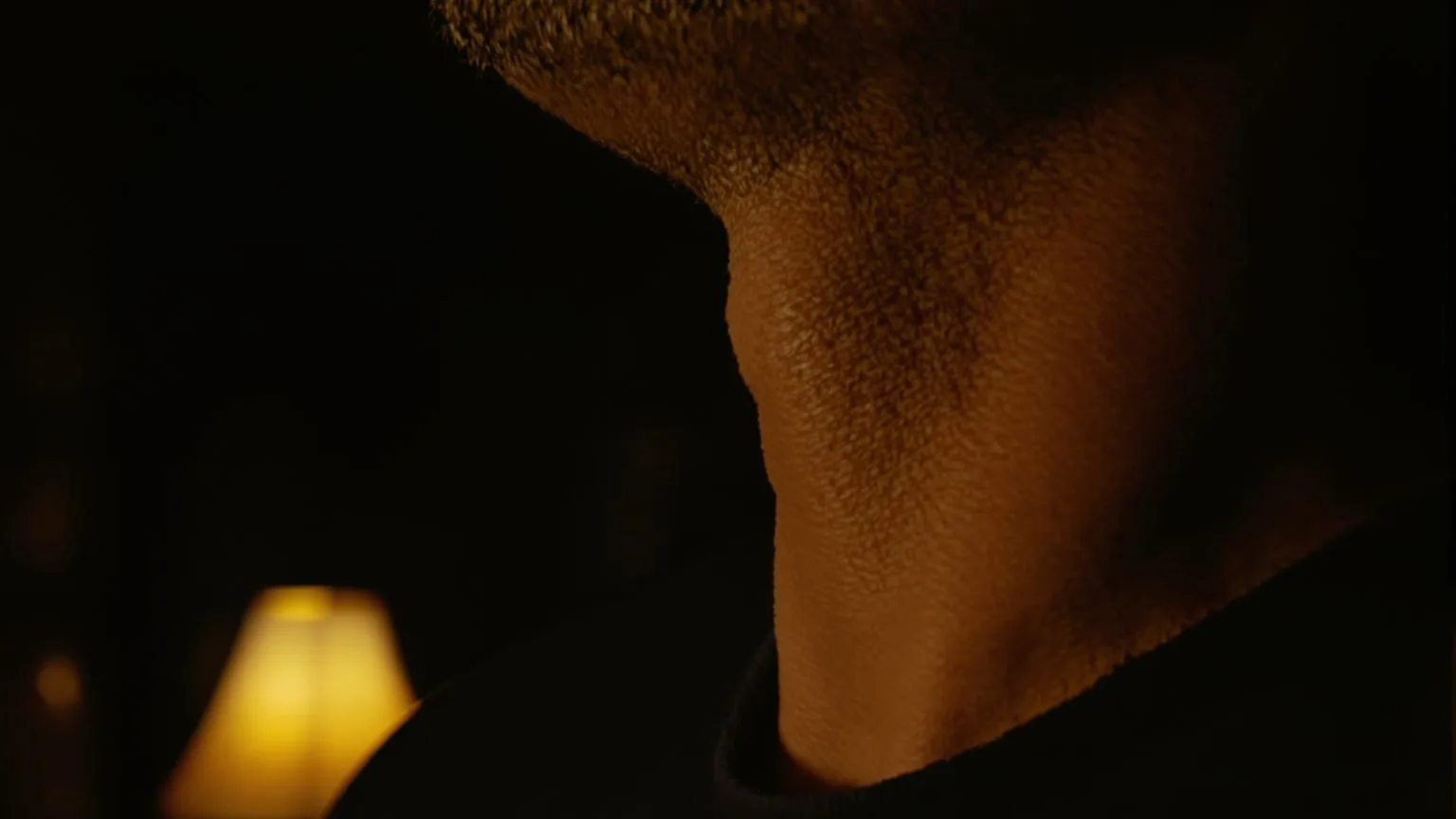 Close-up of a man's throat and neck showing tension, reading the body when words don't come