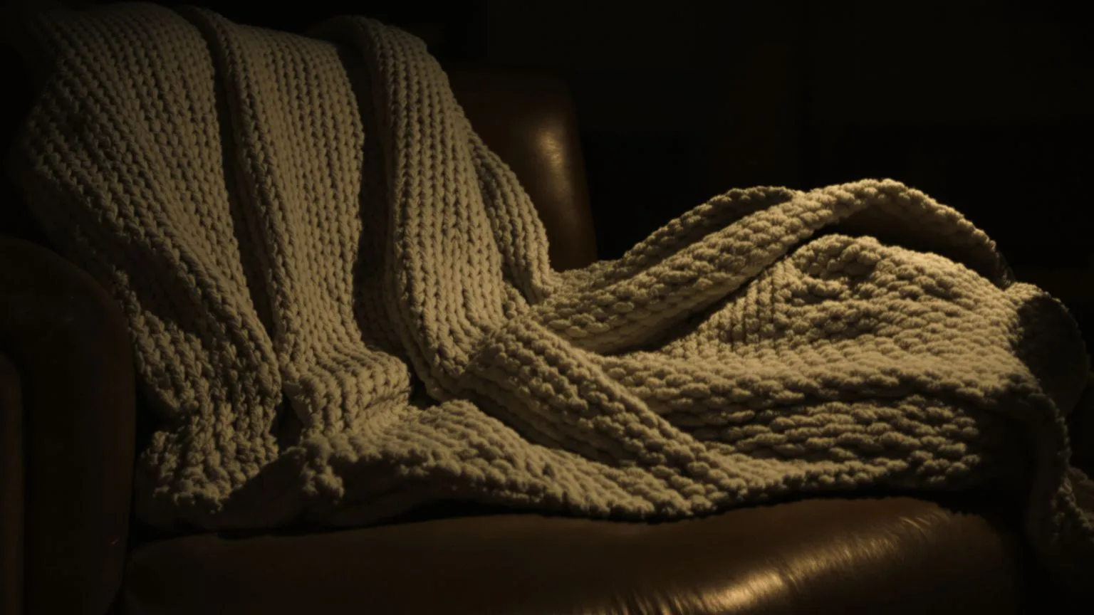 Wool blanket draped on armchair with body impression showing protective comfort not brokenness