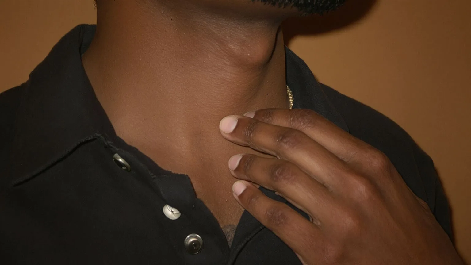 Close-up of hand resting on collarbone near throat showing emotional validation examples through body awareness