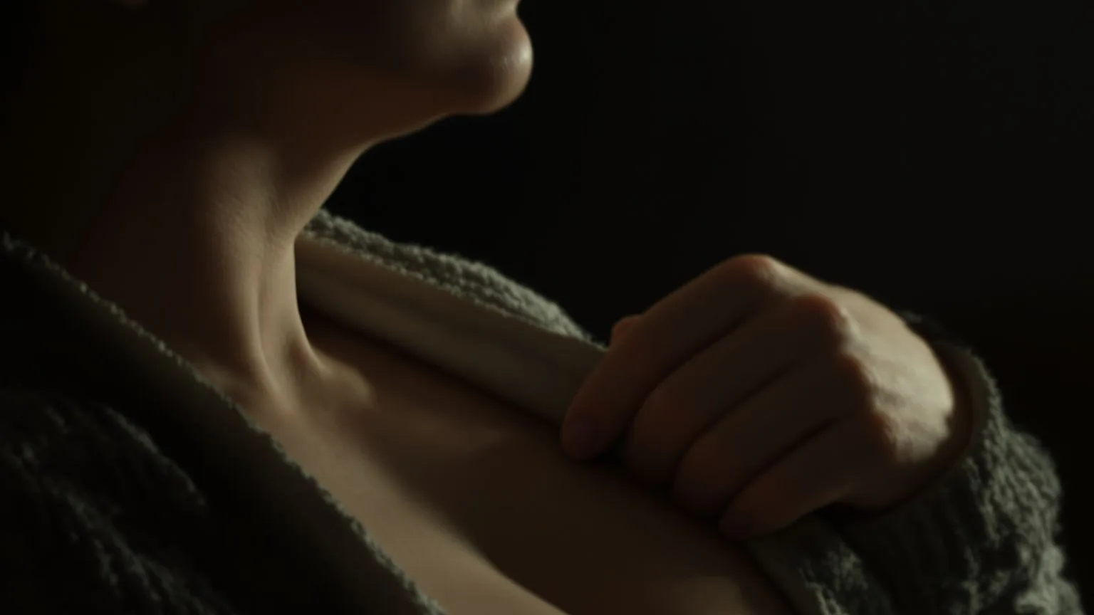 Close-up of a pregnant woman's throat and neck with fingers loosening her collar, releasing tension