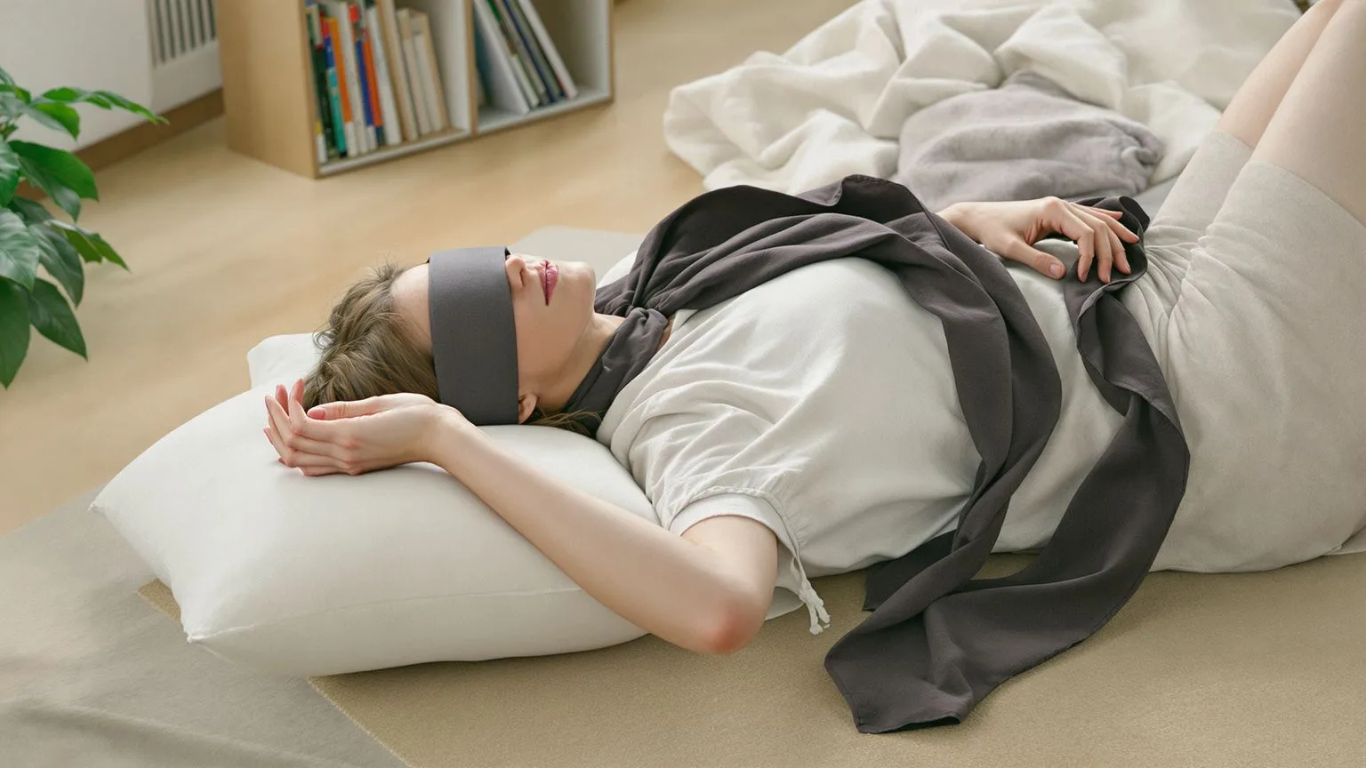 Woman in Feeling Session posture on wooden floor showing a reset for the emotionally drained loop