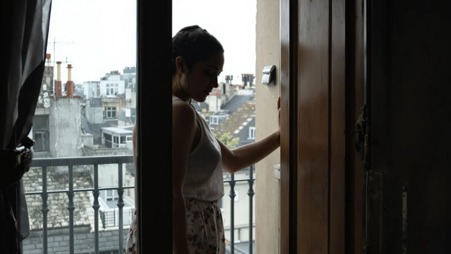 Woman standing in a balcony doorway threshold, body half-turned, illustrating why just let people in Woman standing in a balcony doorway threshold, body half-turned, illustrating why just let people in doesn't work