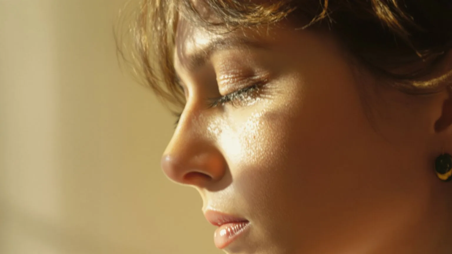 Close-up of a woman's glistening eyes with a tear track showing the connection to crying after numbness